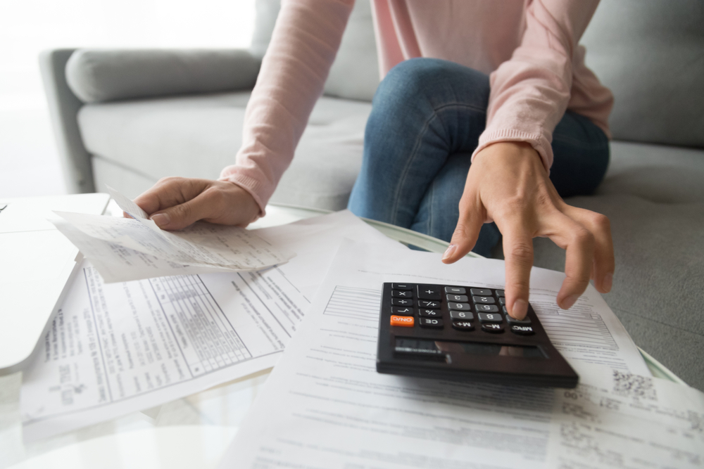 Woman,Renter,Holding,Paper,Bills,Using,Calculator,For,Business,Financial